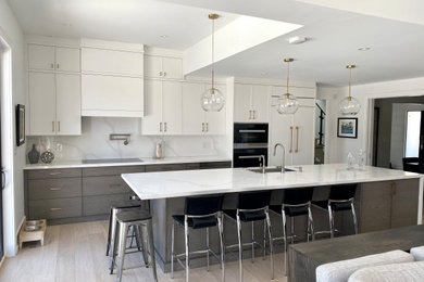 Example of a large trendy single-wall light wood floor open concept kitchen design in Toronto with an undermount sink, flat-panel cabinets, white cabinets, quartz countertops, white backsplash, quartz backsplash, paneled appliances and an island