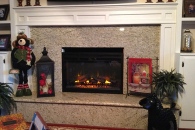 Living room - large traditional open concept medium tone wood floor living room idea in Charlotte with beige walls, a standard fireplace, a stone fireplace and a wall-mounted tv