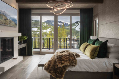 Inspiration for a rustic medium tone wood floor and brown floor bedroom remodel in Other with gray walls and a standard fireplace