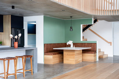 Inspiration for a beach style dining room in Sunshine Coast with concrete floors.