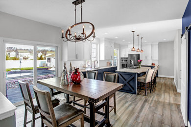 Eat-in kitchen - mid-sized transitional l-shaped vinyl floor and brown floor eat-in kitchen idea in Other with a single-bowl sink, shaker cabinets, white cabinets, granite countertops, white backsplash, porcelain backsplash, an island and white countertops