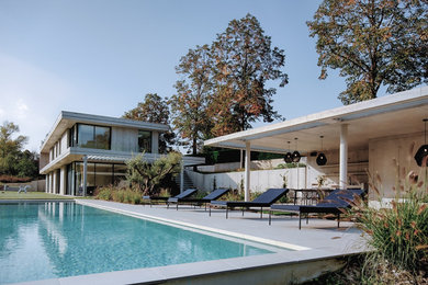 Aménagement d'un grand piscine avec aménagement paysager latéral contemporain rectangle.