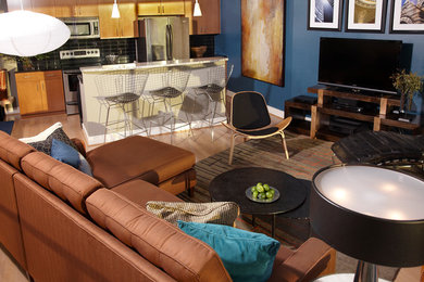 Example of a mid-sized minimalist open concept medium tone wood floor living room design in Atlanta with blue walls and a tv stand