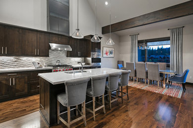 Large transitional l-shaped medium tone wood floor eat-in kitchen photo in Sacramento with a double-bowl sink, shaker cabinets, dark wood cabinets, laminate countertops, gray backsplash, ceramic backsplash, stainless steel appliances and an island