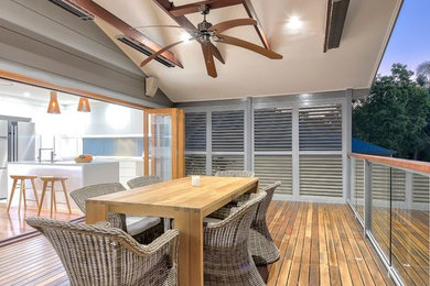 Inspiration for a mid-sized modern backyard deck remodel in Other with a roof extension