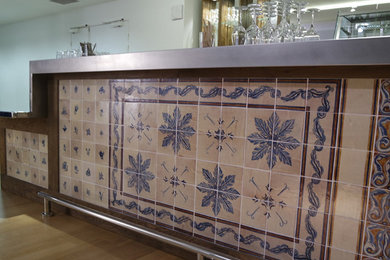 Aménagement d'un bar de salon linéaire méditerranéen avec un évier intégré, un plan de travail en zinc, une crédence en céramique, parquet clair et un sol beige.