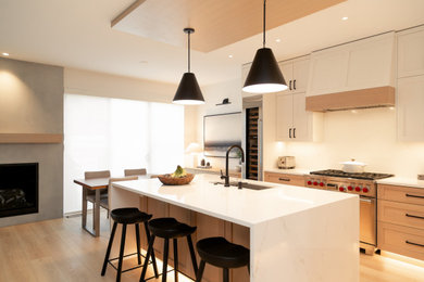 Inspiration for a modern l-shaped vinyl floor and brown floor eat-in kitchen remodel in Other with an undermount sink, shaker cabinets, white cabinets, quartz countertops, white backsplash, glass sheet backsplash, stainless steel appliances, an island and white countertops