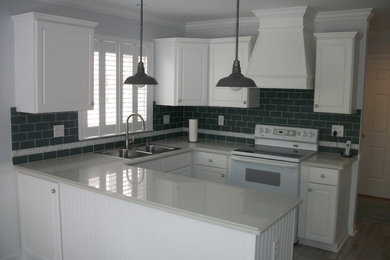 Enclosed kitchen - mid-sized traditional u-shaped light wood floor enclosed kitchen idea in Detroit with a double-bowl sink, raised-panel cabinets, white cabinets, quartzite countertops, gray backsplash, subway tile backsplash, white appliances and no island