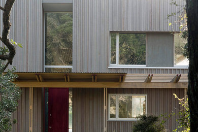 Foto de fachada de casa gris y gris actual de tamaño medio de dos plantas con revestimiento de madera, tejado de un solo tendido, tejado de metal y panel y listón