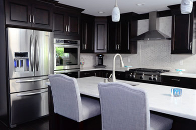 Inspiration for a large contemporary l-shaped porcelain tile eat-in kitchen remodel in New York with an undermount sink, raised-panel cabinets, marble countertops, white backsplash, stone tile backsplash, stainless steel appliances and an island