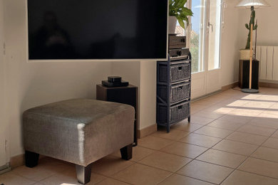 中くらいなトロピカルスタイルのおしゃれなリビング (グレーの壁、セラミックタイルの床、壁掛け型テレビ、茶色い床) の写真