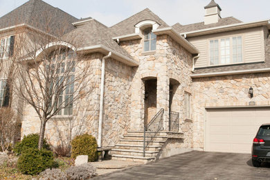 Inspiration for a large timeless brown two-story stone exterior home remodel in San Diego with a hip roof