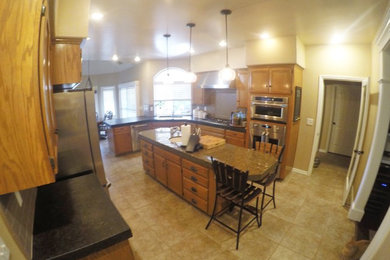 Eat-in kitchen - mid-sized traditional u-shaped ceramic tile and beige floor eat-in kitchen idea in Other with a double-bowl sink, stainless steel appliances, shaker cabinets, medium tone wood cabinets, brown backsplash, ceramic backsplash and an island