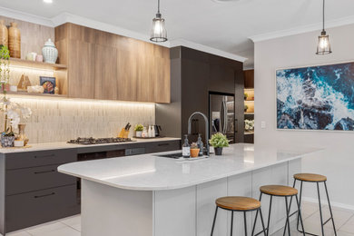Inspiration for a contemporary galley kitchen pantry in Gold Coast - Tweed with an undermount sink, flat-panel cabinets, black cabinets, quartz benchtops, beige splashback, subway tile splashback, black appliances, porcelain floors, with island, white floor and white benchtop.