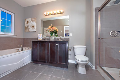 Inspiration for a mid-sized contemporary master gray tile and ceramic tile ceramic tile bathroom remodel in Wilmington with an undermount sink, recessed-panel cabinets, dark wood cabinets, granite countertops, a one-piece toilet and gray walls