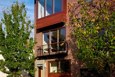 Mid-sized contemporary three-storey red exterior in Philadelphia with a flat roof and mixed siding.