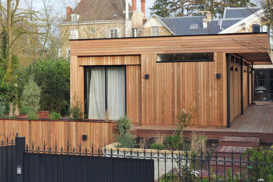 Design ideas for a large contemporary one-storey beige townhouse exterior in Paris with wood siding and a flat roof.