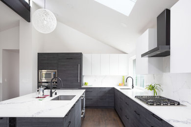 Trendy l-shaped dark wood floor, brown floor and vaulted ceiling eat-in kitchen photo in Seattle with a single-bowl sink, flat-panel cabinets, black cabinets, quartz countertops, white backsplash, quartz backsplash, paneled appliances, an island and white countertops