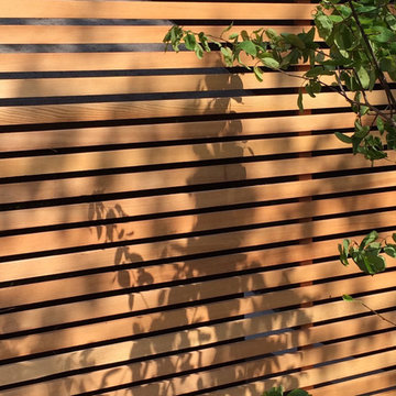 Garapa decking and Cedar screens create modern family garden