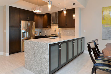 Mid-sized trendy porcelain tile eat-in kitchen photo in Tampa with a drop-in sink, dark wood cabinets, brown backsplash, stainless steel appliances and quartzite countertops