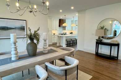 Medium sized traditional kitchen/dining room in Boston with white walls, dark hardwood flooring, a corner fireplace, a tiled fireplace surround and brown floors.