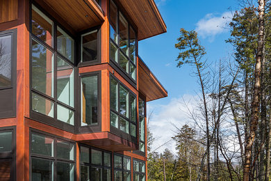 Inspiration for a mid-sized modern brown three-story wood house exterior remodel in Burlington with a shed roof and a metal roof