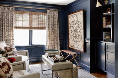 Inspiration for an eclectic enclosed living room in New York with a library, blue walls and a built-in media wall.