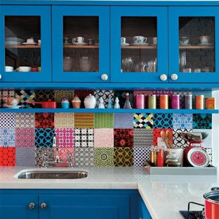 Imagen de cocina en L, ecléctica, de tamaño medio, con fregadero bajoencimera, armarios estilo shaker, puertas de armario azules, encimera de acrílico, salpicadero multicolor, salpicadero de azulejos de cerámica y península