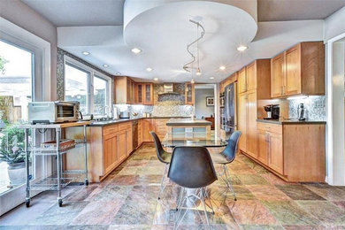 Huge transitional u-shaped ceramic tile eat-in kitchen photo in Orange County with a double-bowl sink, flat-panel cabinets, light wood cabinets, quartz countertops, multicolored backsplash, mosaic tile backsplash, stainless steel appliances and an island