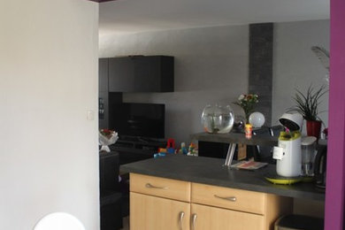 This is an example of a medium sized contemporary l-shaped open plan kitchen in Clermont-Ferrand with beaded cabinets, light wood cabinets, no island and grey worktops.