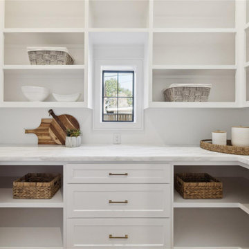 Bright prep kitchen with marble counters and open shelving