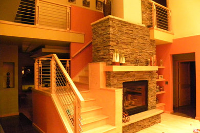 Inspiration for a large contemporary open concept light wood floor family room remodel in Milwaukee with orange walls, a standard fireplace, a brick fireplace and no tv