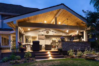 Outdoor kitchen deck - mid-sized transitional outdoor kitchen deck idea in Seattle with a roof extension