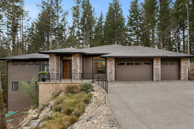 Inspiration for a large contemporary brown two-story wood house exterior remodel in Portland with a hip roof and a shingle roof