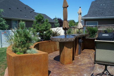 Mid-sized mountain style backyard concrete patio kitchen photo in Boise with no cover