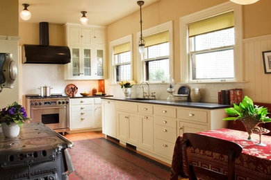 Eat-in kitchen - large l-shaped medium tone wood floor eat-in kitchen idea in Portland with an undermount sink, flat-panel cabinets, white cabinets, granite countertops and stainless steel appliances