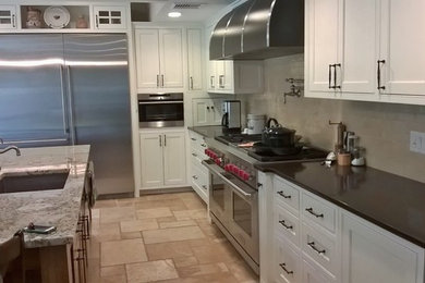 Transitional porcelain tile kitchen photo in Minneapolis with an undermount sink, recessed-panel cabinets, white cabinets, granite countertops, beige backsplash, glass tile backsplash and stainless steel appliances
