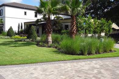 Großer Klassischer Garten im Innenhof mit Auffahrt, direkter Sonneneinstrahlung und Pflastersteinen in Orlando