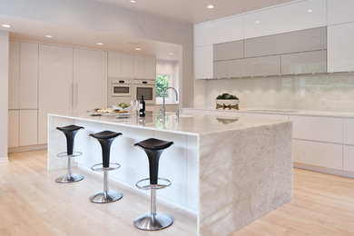 Inspiration for a large contemporary l-shaped eat-in kitchen in Dallas with an undermount sink, flat-panel cabinets, white cabinets, quartz benchtops, white splashback, glass sheet splashback, white appliances, light hardwood floors, with island, yellow floor and white benchtop.