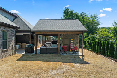 Inspiration for a timeless backyard concrete paver patio kitchen remodel in Other with a roof extension