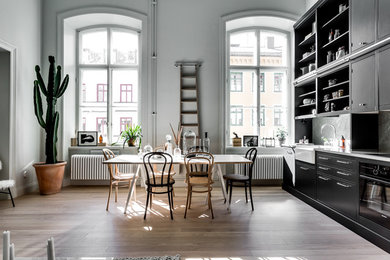 This is an example of a large scandinavian open plan dining in Stockholm with grey walls, no fireplace and medium hardwood floors.