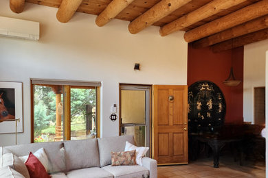 Living room - small southwestern open concept ceramic tile, beige floor and exposed beam living room idea in Albuquerque with white walls, a standard fireplace, a plaster fireplace and a media wall