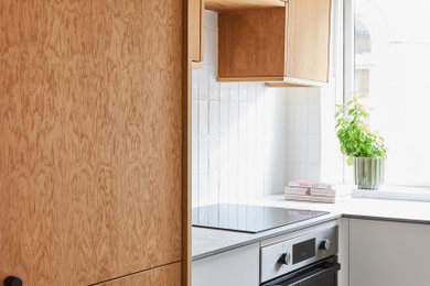 Small contemporary u-shaped enclosed kitchen in Other with a built-in sink, flat-panel cabinets, light wood cabinets, concrete worktops, ceramic splashback, no island, grey floors and grey worktops.