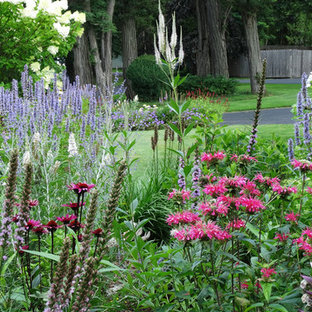 Small arts and crafts front yard partial sun driveway in New York with a garden path and brick pavers for summer.