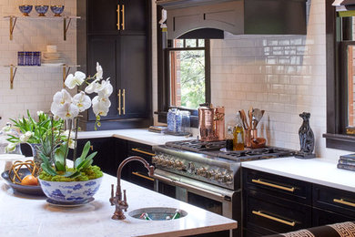 Transitional l-shaped eat-in kitchen photo in Raleigh with recessed-panel cabinets, black cabinets, quartz countertops, white backsplash, ceramic backsplash, stainless steel appliances and an island
