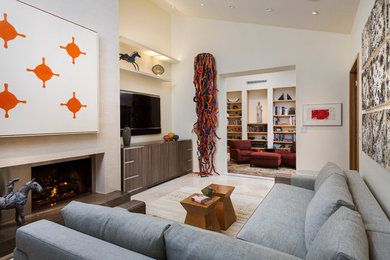 Mid-sized trendy enclosed beige floor family room photo in Phoenix with beige walls, a standard fireplace, a plaster fireplace and a wall-mounted tv