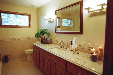Inspiration for a transitional beige tile and ceramic tile ceramic tile corner shower remodel in Phoenix with an undermount sink, furniture-like cabinets, medium tone wood cabinets, quartz countertops, a two-piece toilet and beige walls