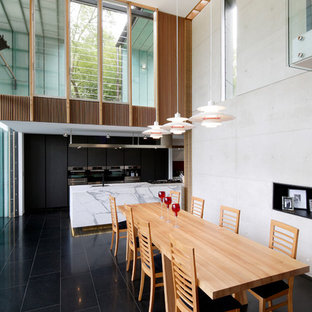 Cette image montre une grande salle à manger ouverte sur le salon design avec un sol noir.