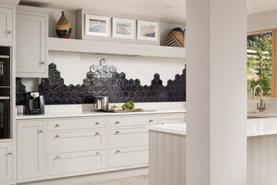 Inspiration for a mid-sized country u-shaped porcelain tile and gray floor kitchen remodel in Essex with a drop-in sink, shaker cabinets, gray cabinets, quartz countertops, blue backsplash, ceramic backsplash, paneled appliances, a peninsula and white countertops