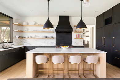 Eat-in kitchen - large contemporary l-shaped medium tone wood floor and beige floor eat-in kitchen idea in Minneapolis with a drop-in sink, flat-panel cabinets, black cabinets, marble countertops, white backsplash, marble backsplash, stainless steel appliances, an island and white countertops